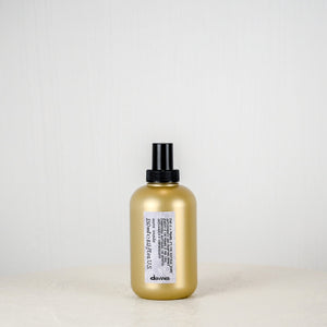 Gold bottle with black cap on a light gray background