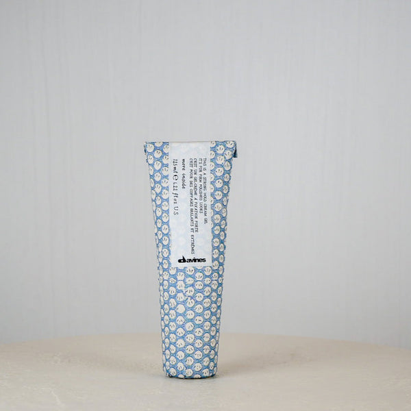 Tube of cream with blue floral pattern on a white background