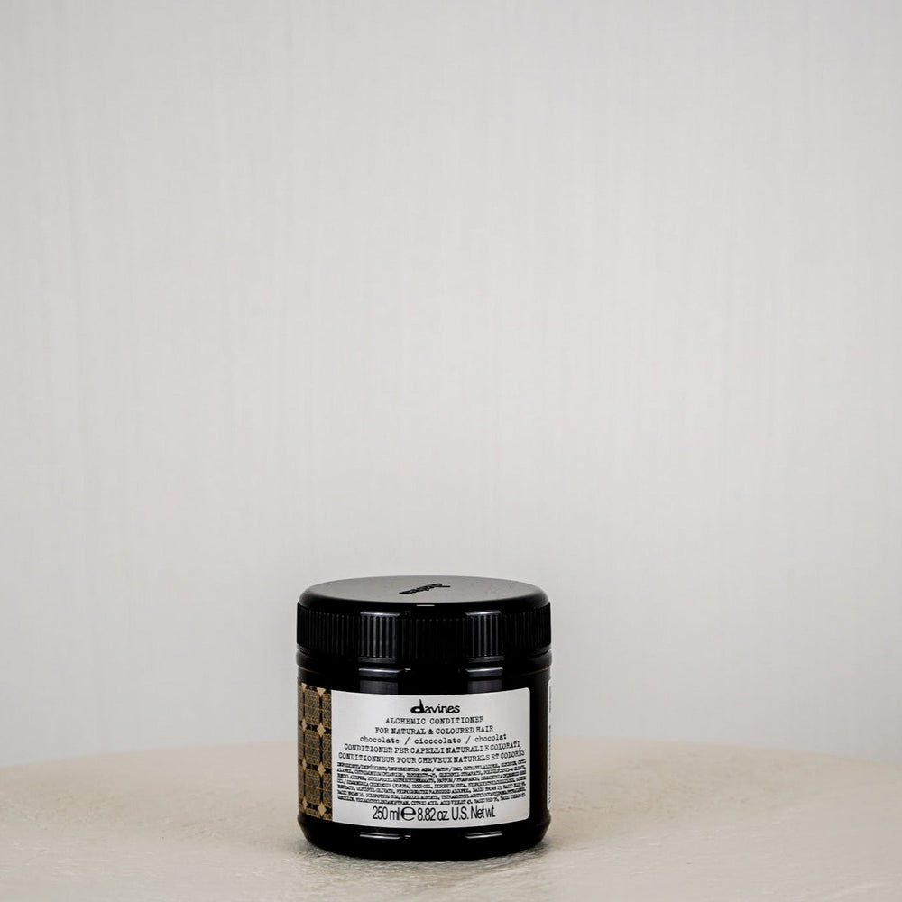 Jar of Davines hair product on a white surface with a white background