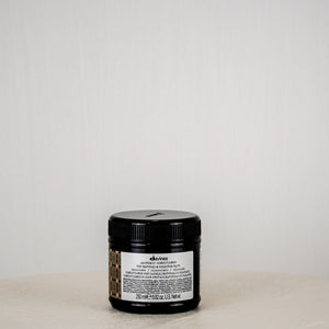 Jar of Davines hair product on a white surface with a white background