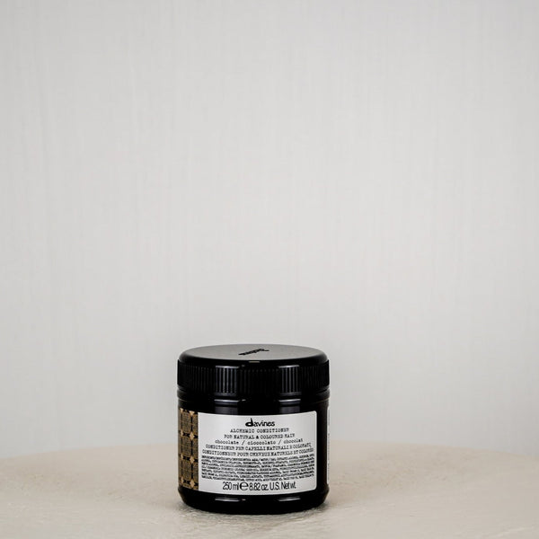 Jar of Davines hair product on a white surface with a white background