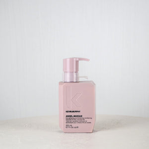 Pink bottle of Kevin Murphy hair product on a white surface with a white background