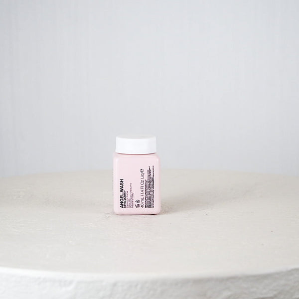 Pink container with white cap on a white surface against a light gray background
