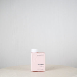 Pink bottle of Revlonmurphy hair product on a white surface with a light gray background