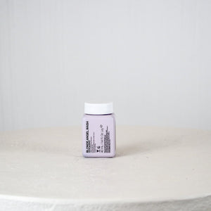 Small white container with a label on a light gray surface and background