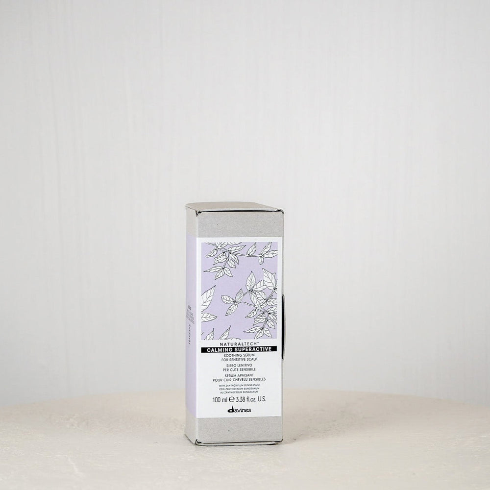 Skincare product packaging on a white surface with a light gray background