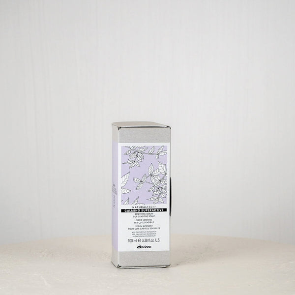 Skincare product packaging on a white surface with a light gray background