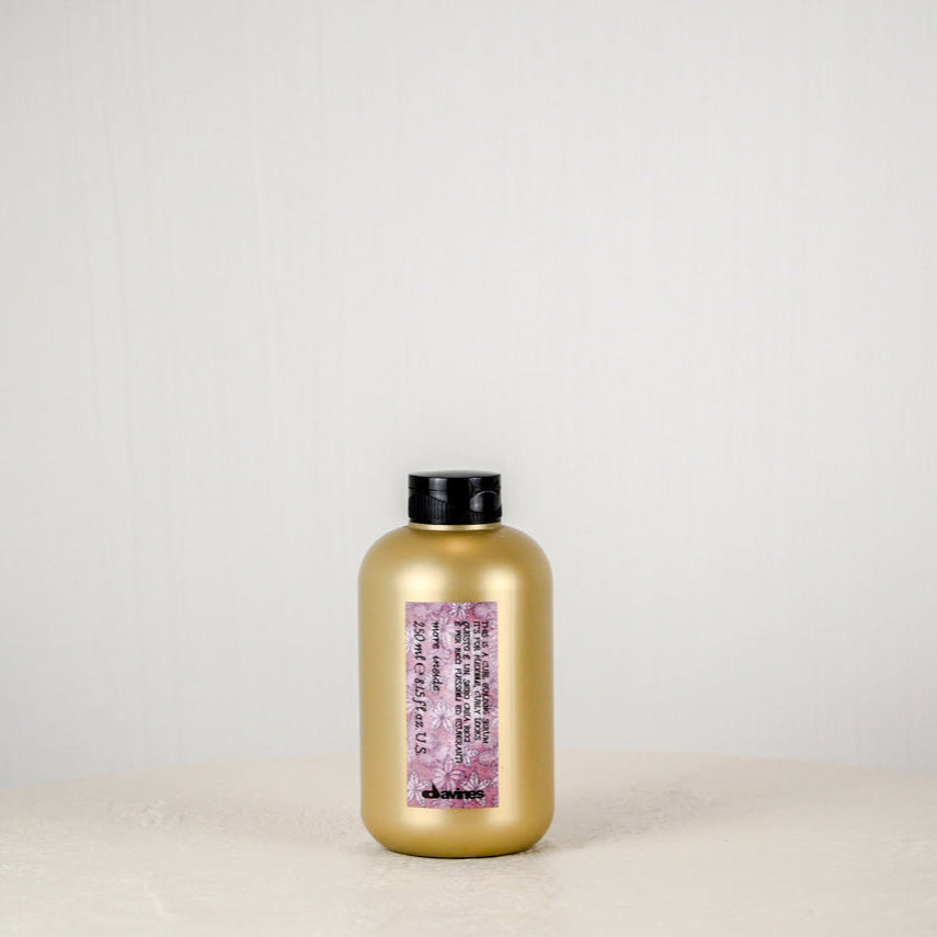 Pink soap bar with a label on a white surface against a light gray background