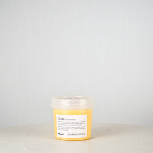 Davines DEDE conditioner bottle on a light gray background