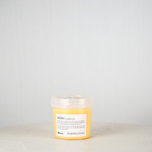 Davines DEDE conditioner bottle on a light gray background