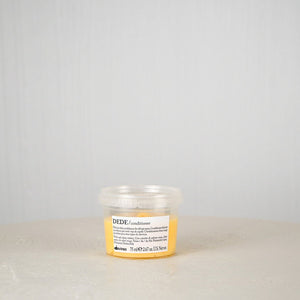 Small jar with a label on a white surface and light gray background