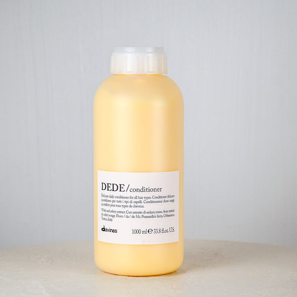 Yellow bottle of Dede conditioner on a gray background
