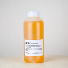 Bottle of DEDE shampoo with a white label on a light background