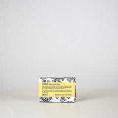 Bar of soap with a yellow label on a white surface