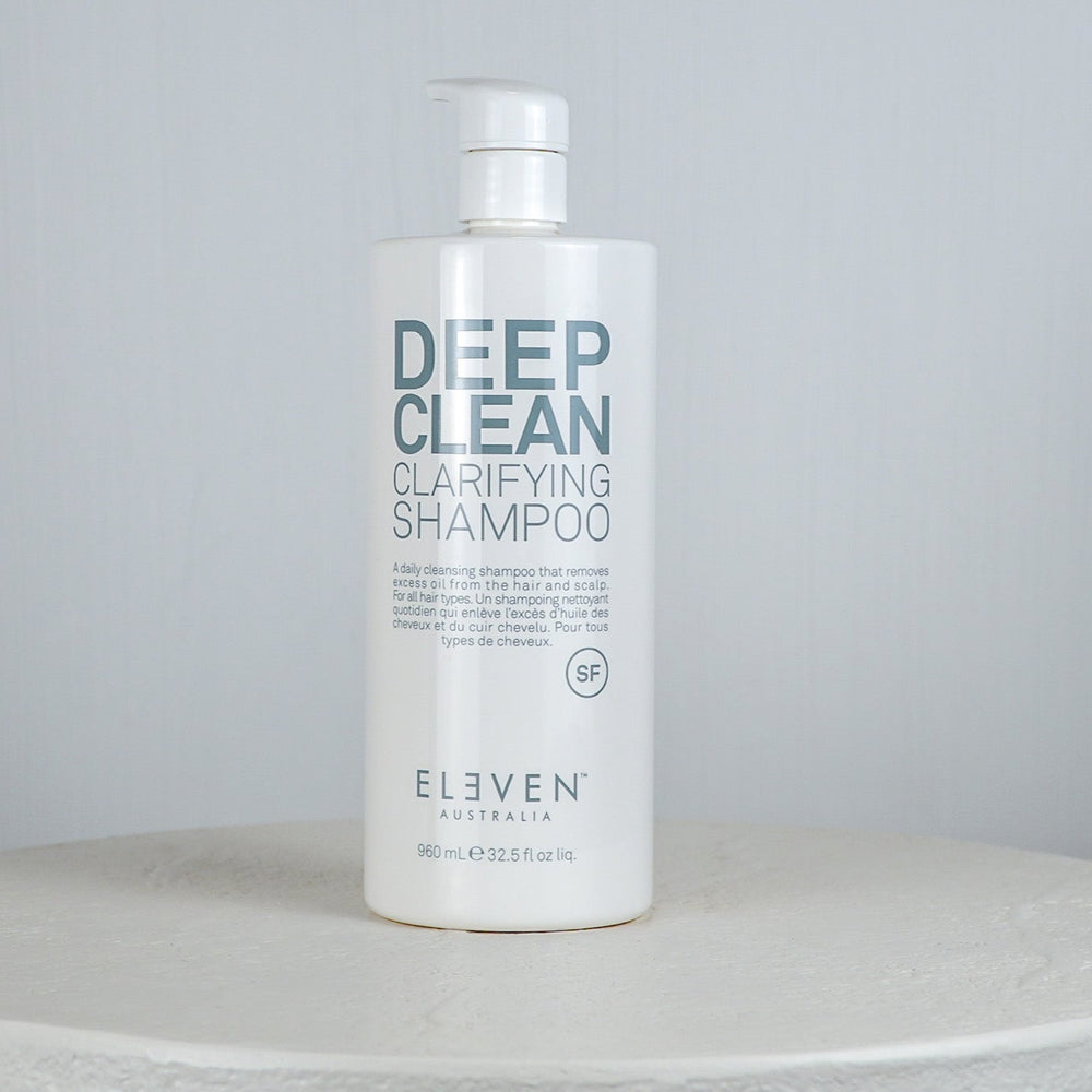 Shampoo bottle labeled 'Deep Clean Clarifying Shampoo' by 'Eleven' on a white surface with a light gray background