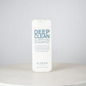 Shampoo bottle labeled 'Deep Clean Clarifying Shampoo' by 'Eleven' on a white surface with a light gray background