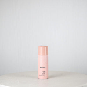 Pink bottle on a white surface with a light gray background