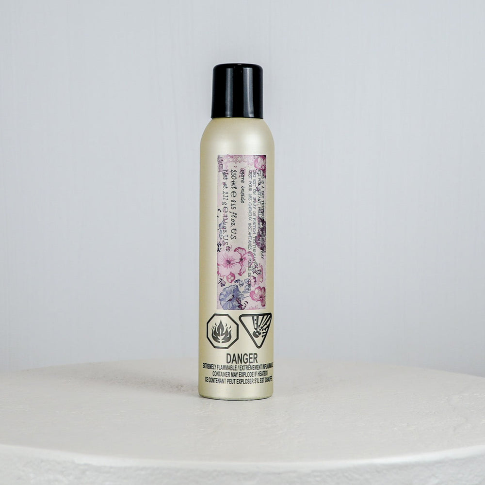 Hair product bottle with floral label on a white surface