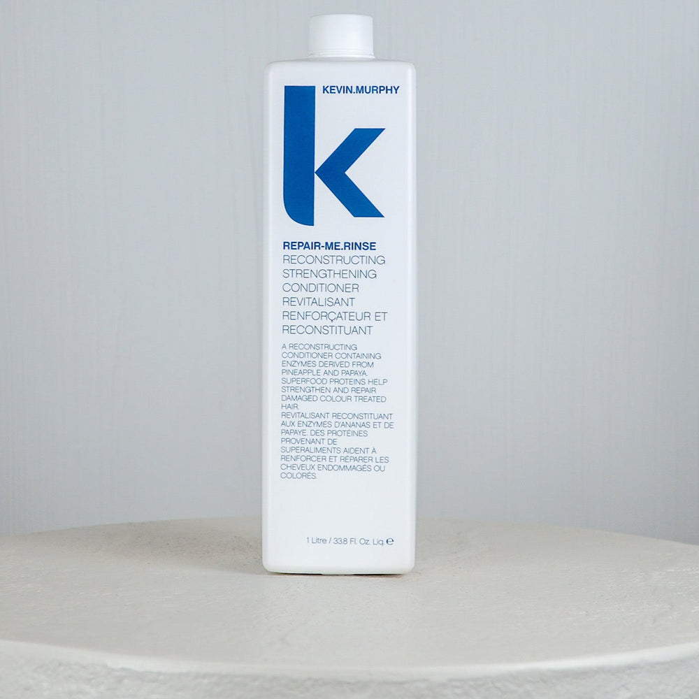 Blue bottle of Kevin Murphy hair product on a white surface with a white background