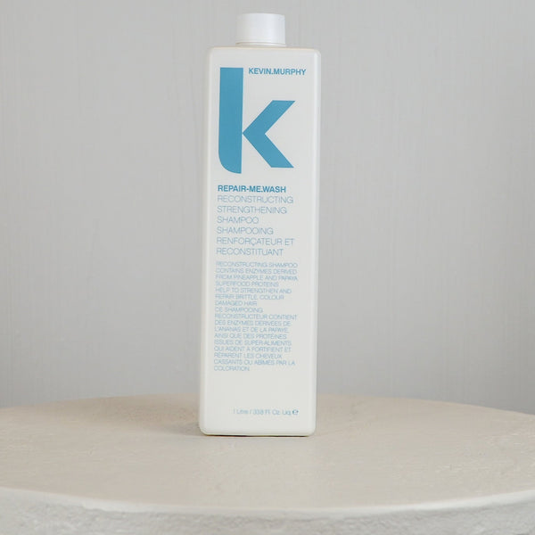 Kerstin Adolf repair shampoo bottle on a round white surface with a gray background