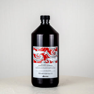 Bottle of shampoo with a decorative label on a white surface