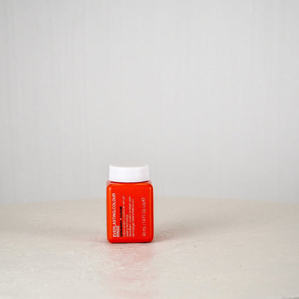 Red pill bottle with white cap on a light gray background