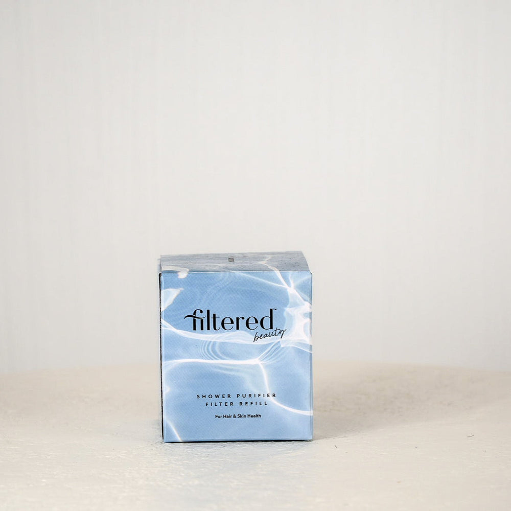 Box of 'filtered beauty' shower purifier filter refill on a light gray background