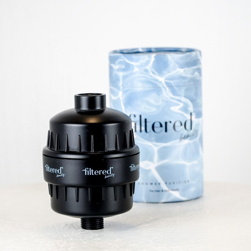 Chrome water filter and blue cylindrical packaging with 'filtered' branding on a light gray background