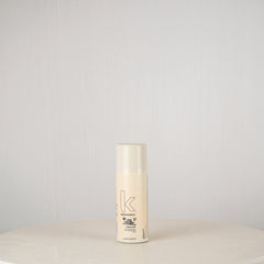 Hair product bottle with brand logo on a light gray background