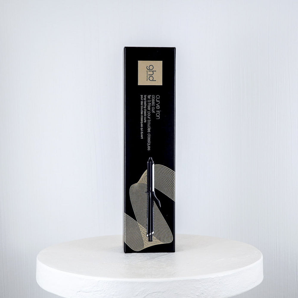 ghd curling iron packaging on a white surface with a white background