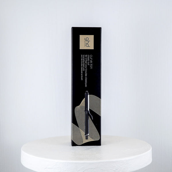 ghd curling iron packaging on a white surface with a white background