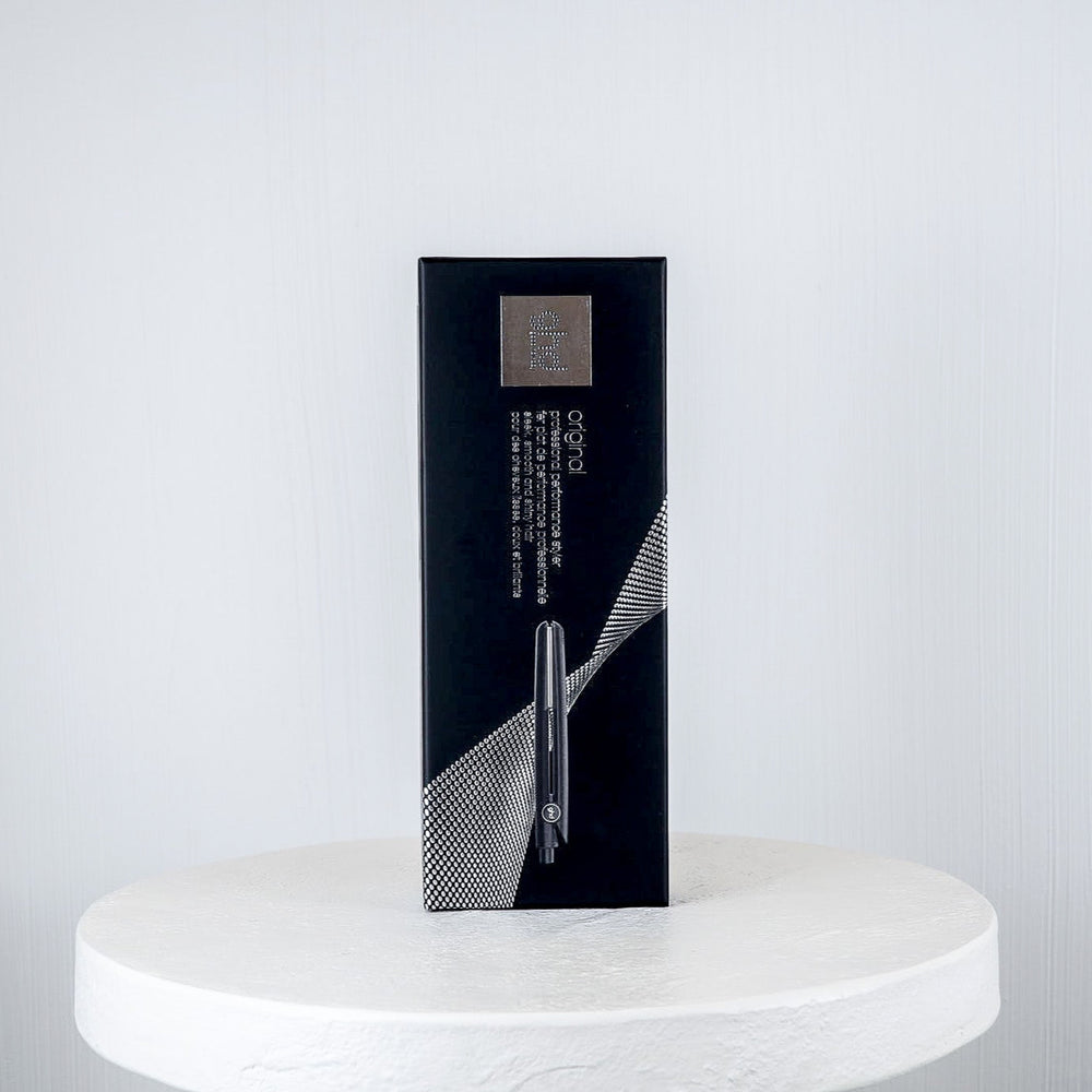 Black box on a white marble surface against a light gray background