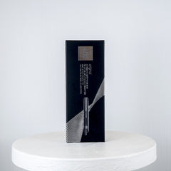 Black box on a white marble surface against a light gray background