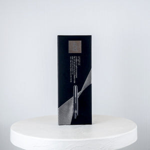 Black box on a white marble surface against a light gray background