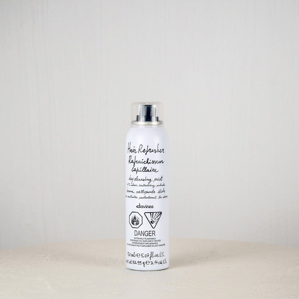 White bottle with black text on a white surface against a light gray background