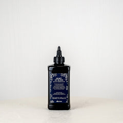 Bottle of hair dye on a white surface with a white background