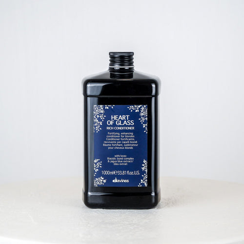 Black bottle of 'Heart of Glass' conditioner with blue label on a white background
