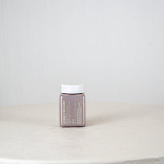 Small rectangular container with a white cap on a light gray surface and background