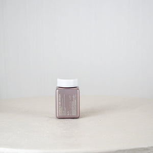 Small rectangular container with a white cap on a light gray surface and background