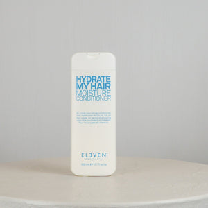 Bottle of 'Hydrate My Hair Moisture Conditioner' by Eleven on a neutral background