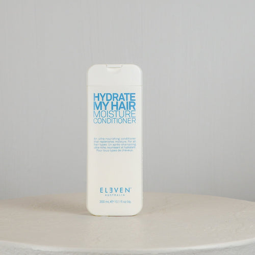 Bottle of 'Hydrate My Hair Moisture Conditioner' by Eleven on a neutral background