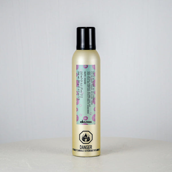 Hair product bottle with floral label on a light gray background