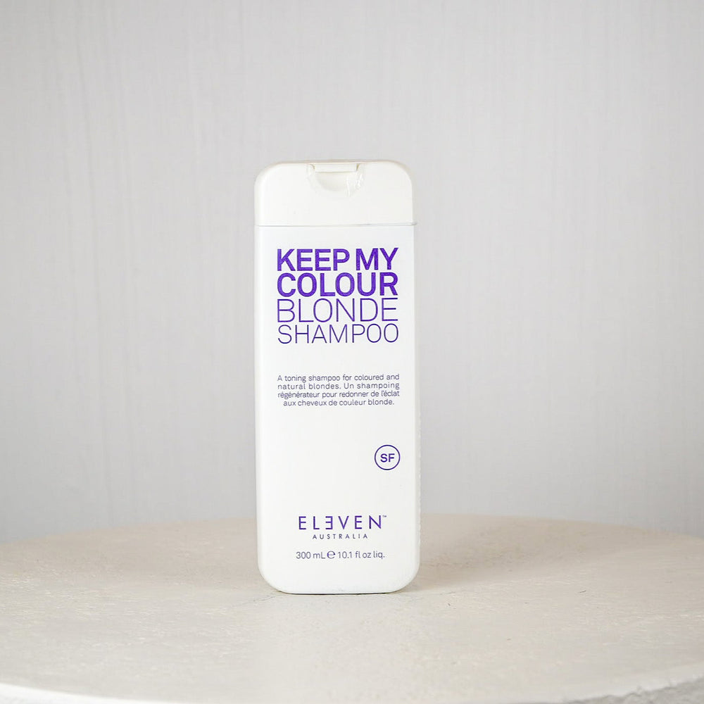 Shampoo bottle labeled 'Keep My Colour Blonde Shampoo' by Eleven Australia on a white surface with a gray background.