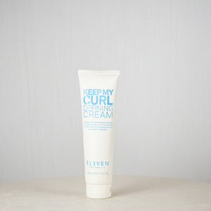 Tube of 'Keep My Curl Defining Cream' by Eleven on a white surface with a light gray background