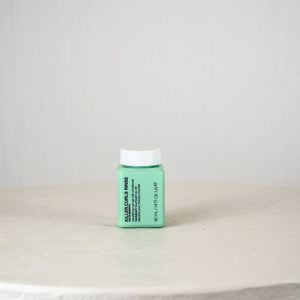 Green bottle with white cap on a light gray surface