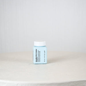 Blue container with white lid on a white surface