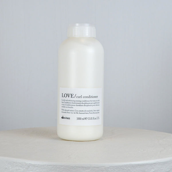 Bottle of Davines LOVE/curl conditioner on a light gray background