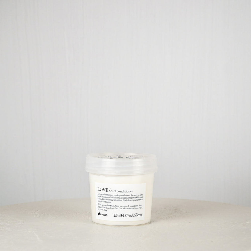White candle with a label on a white surface against a gray background