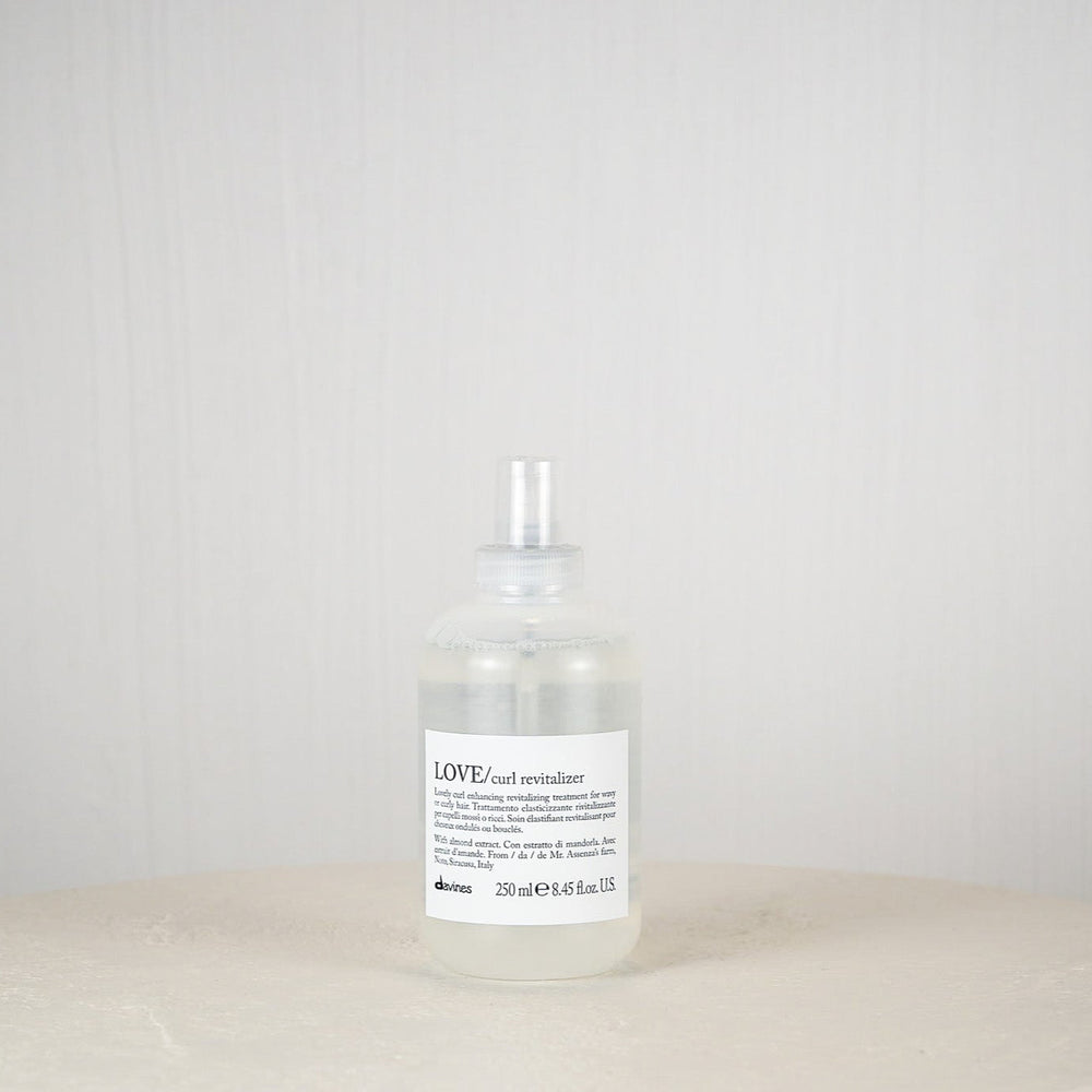 Bottle of L'Oreal hair product on a white surface with a white background