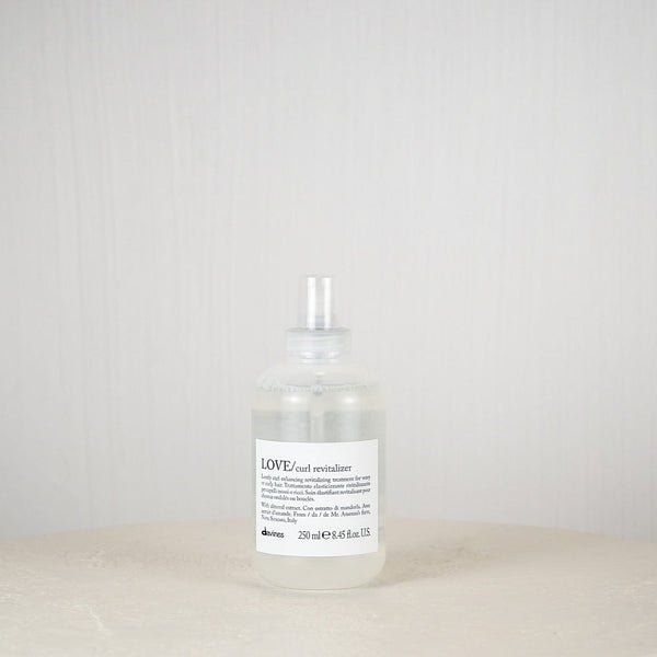 Bottle of L'Oreal hair product on a white surface with a white background